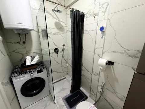 Moderne kupatilo sa tuš kabinom, veš mašinom i mermernim pločicama. - image 8