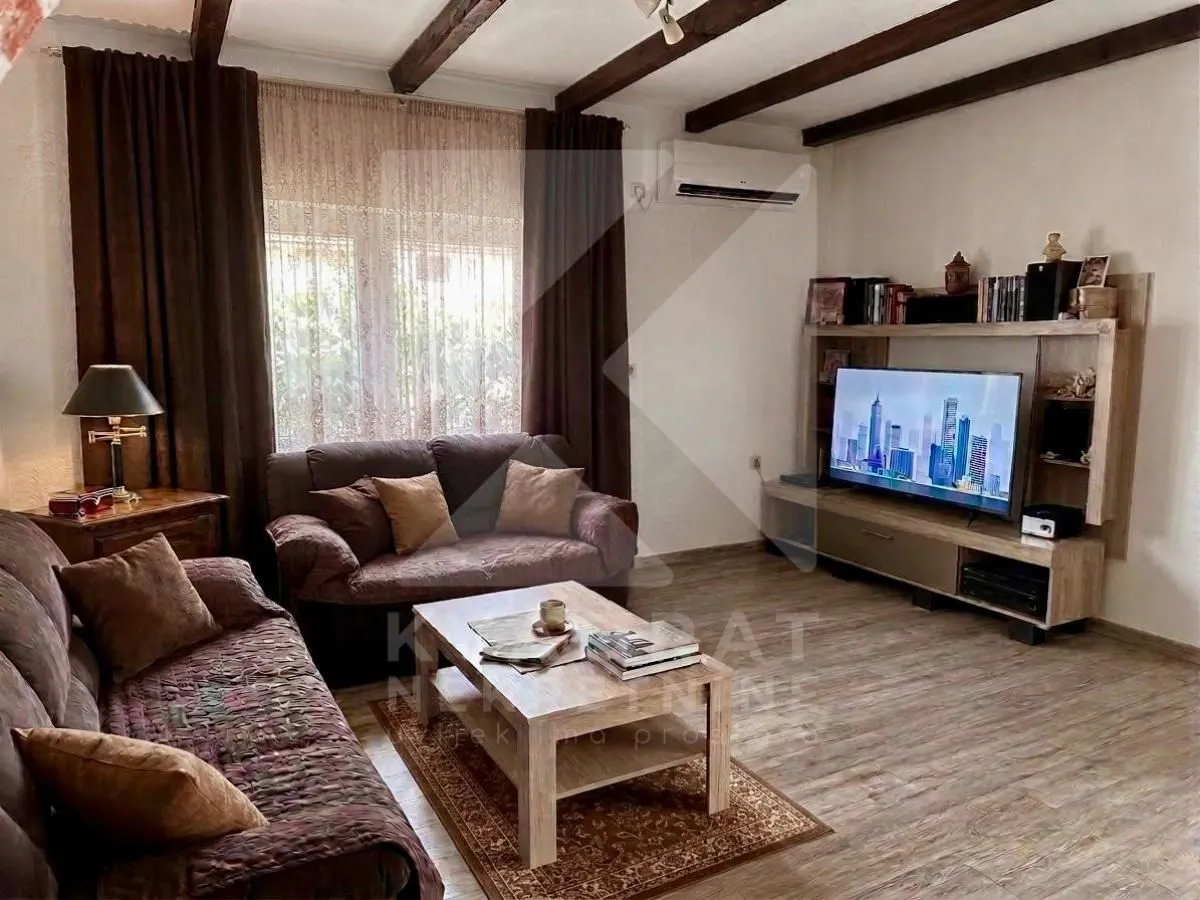 Dnevna soba sa garniturom, stočićem i TV komodom.