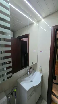 Small bathroom with a sink, mirror, and tiles. - image 10