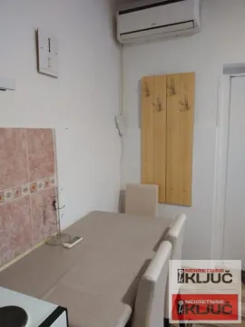 Manja trpezarija sa stolom, stolicama i klima uređajem na zidu. - image 4