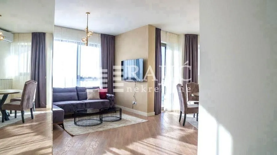 Living room with a sofa, dining area, and access to the terrace.