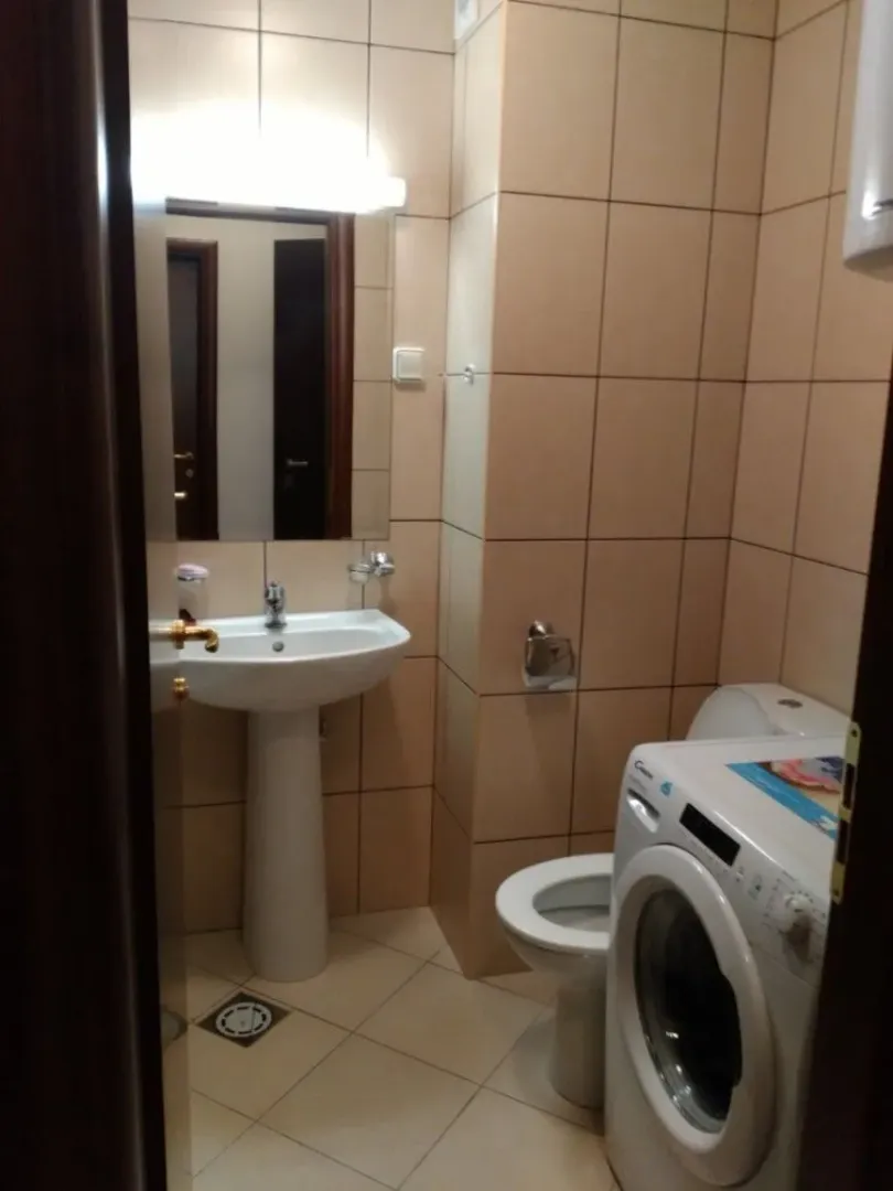 Jednostavno kupatilo sa lavaboom, toalet šoljom i veš mašinom.