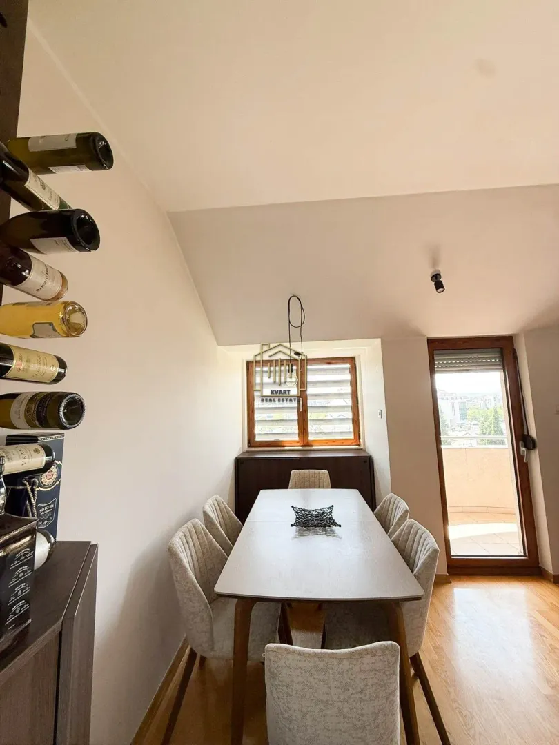Dining area with a table, chairs, and a wall-mounted wine rack.