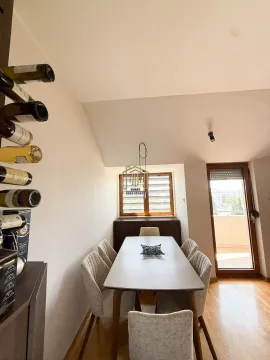 Dining area with a table, chairs, and a wall-mounted wine rack. - image 12