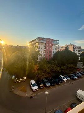 Pogled na zgrade i parking ispred objekta u toku zalaska sunca. - image 8