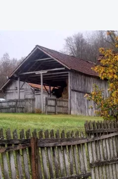 Pogled na stari drveni objekat sa ogradom u dvorištu. - image 17
