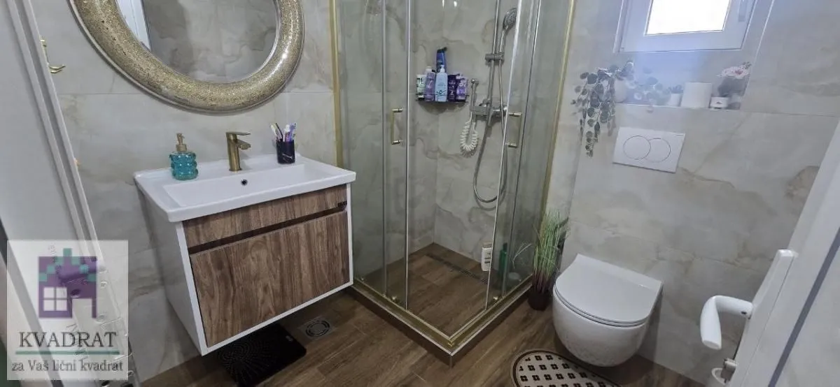 Moderno kupatilo sa tuš kabinom, umivaonikom i WC šoljom.