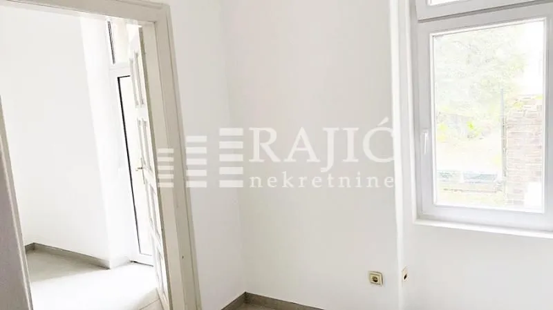 Empty bright room with white walls and a window.