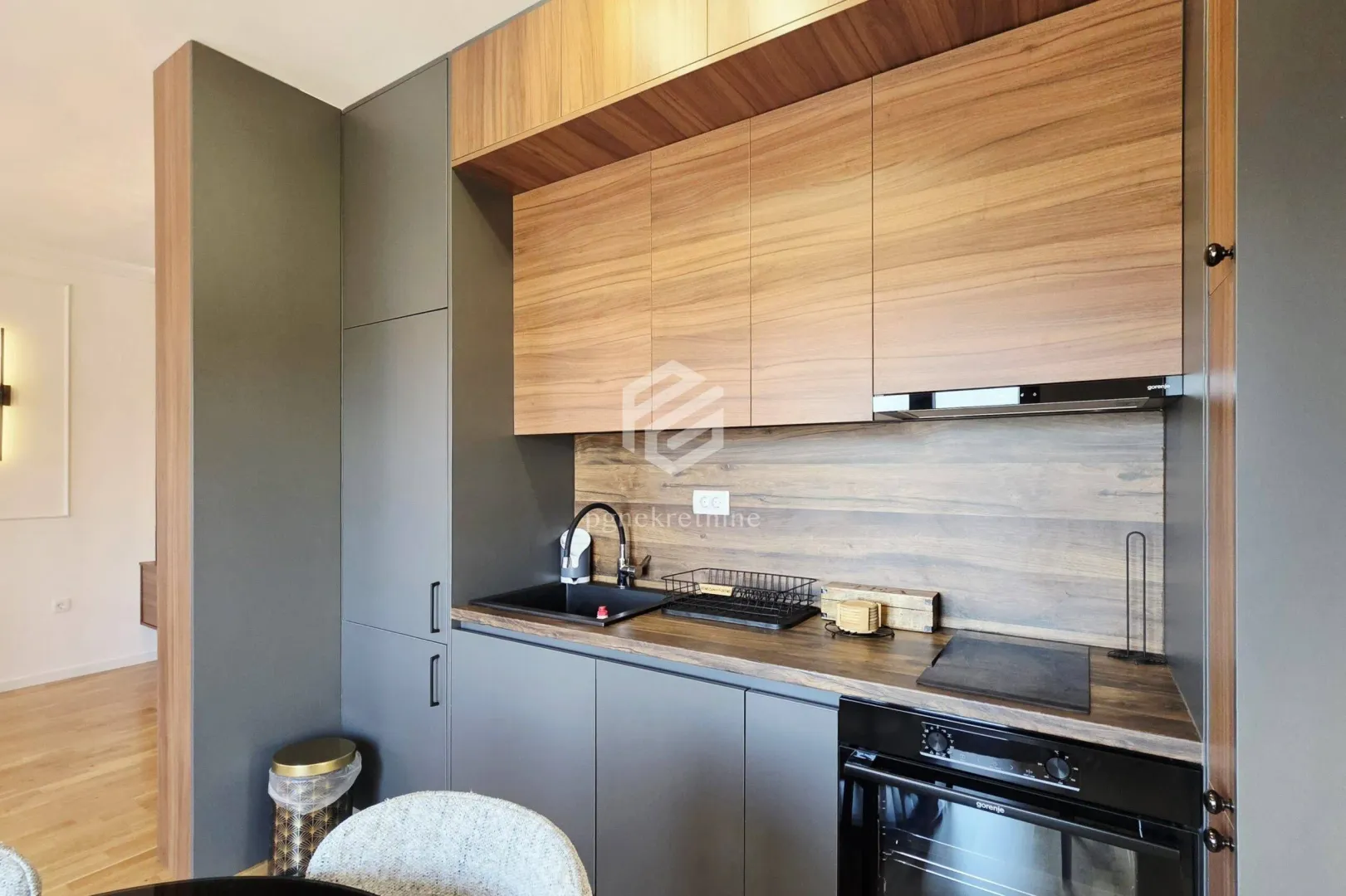 Modern kitchen with dark cabinets and wooden details.
