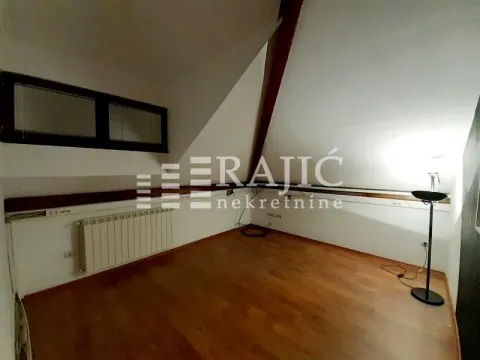 Prazna potkrovna prostorija sa drvenim podom i belim zidovima. - image 16