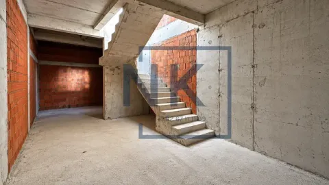 Interior of a property under construction featuring stairs and concrete walls. - image 5
