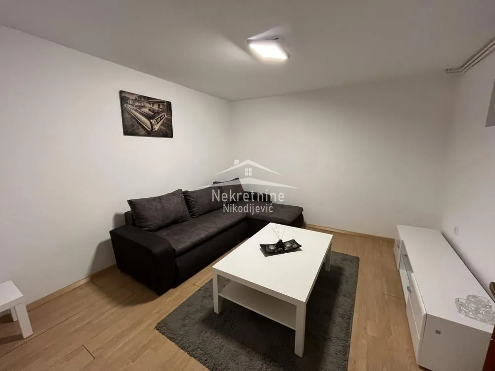 Living room with a sofa, coffee table, and TV unit.