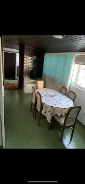 Dining area with a table and chairs, green flooring, and a wooden ceiling. - image 10