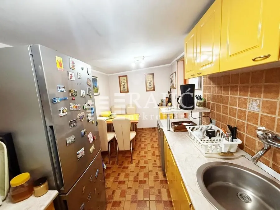 View of the kitchen and dining area with yellow cabinets.