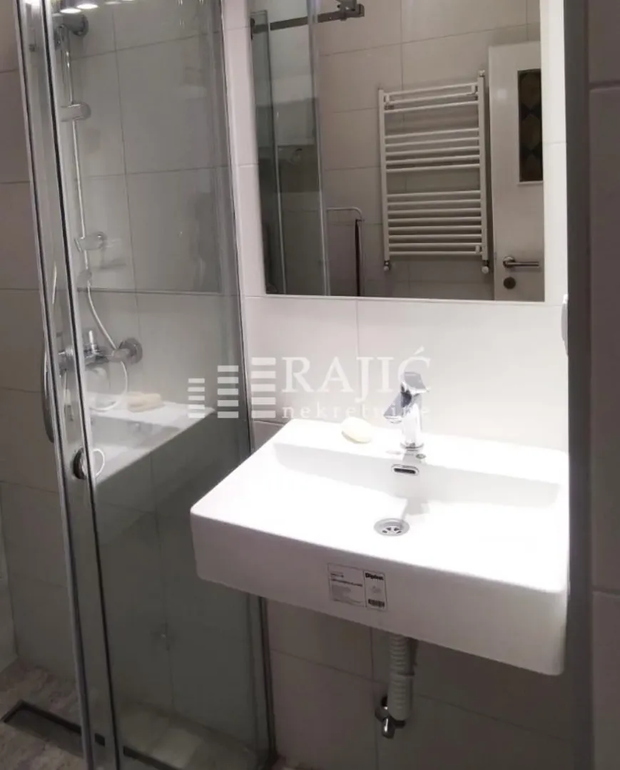 Bathroom with a washbasin and a shower cabin.