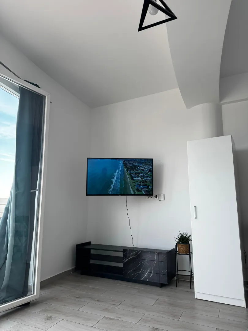 Living room with a TV, TV unit, and wardrobe.