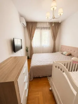 Furnished bedroom with a double bed, cot, and dresser. - image 6