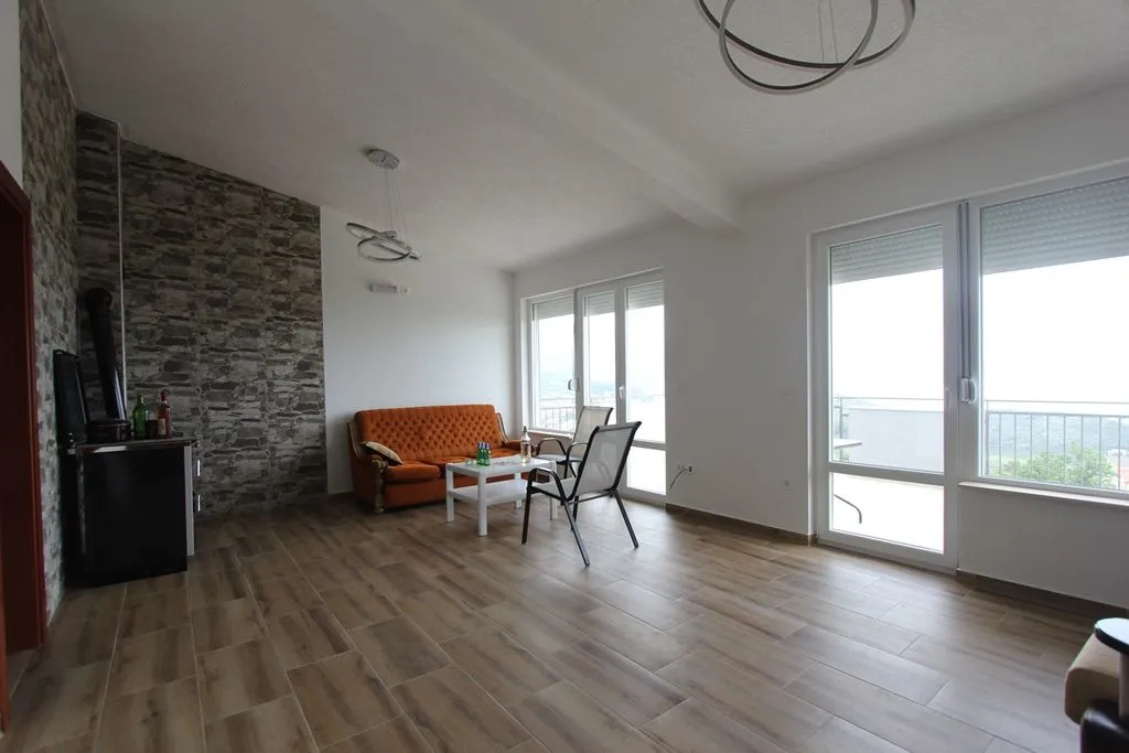 Bright living room with wood-look tile flooring and a stone accent wall.