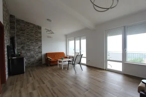 Bright living room with wood-look tile flooring and a stone accent wall. - image 6