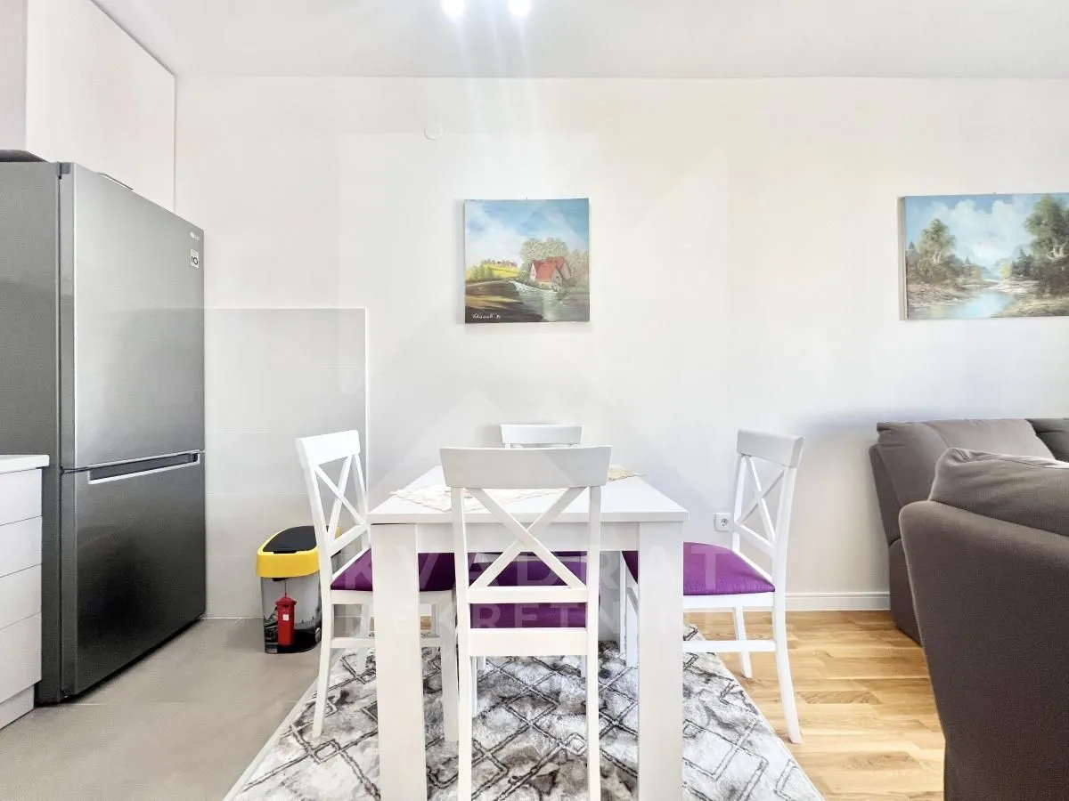Dining area with a white table and chairs as part of the living room.