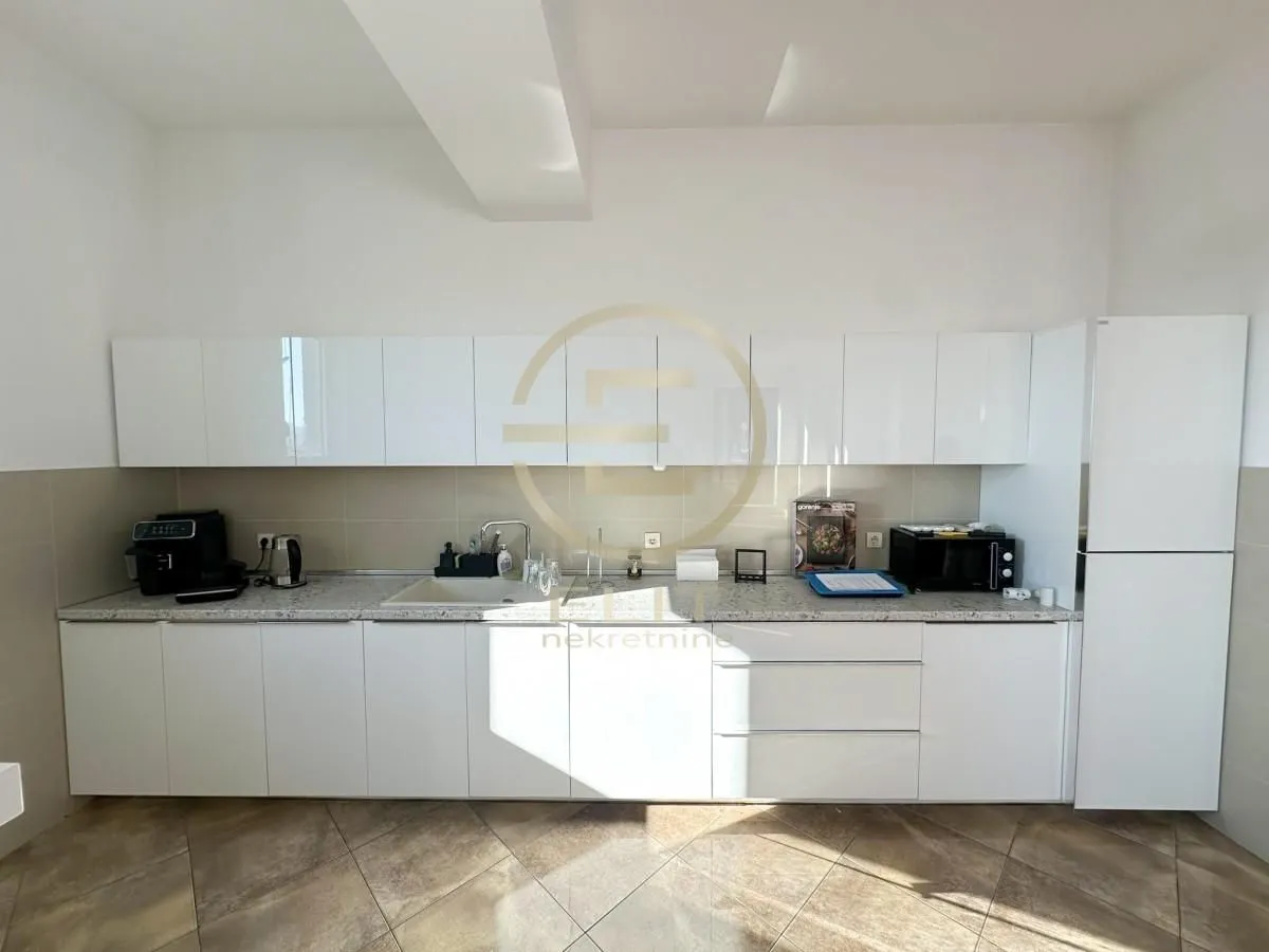 White kitchen with cabinets and a refrigerator.