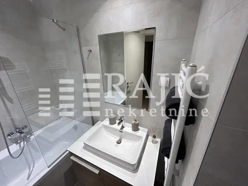 Modern equipped bathroom with a washbasin and a bathtub.