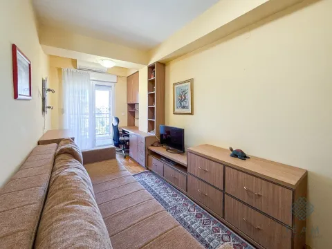 Living room with a sofa, TV unit, and desk. - image 8