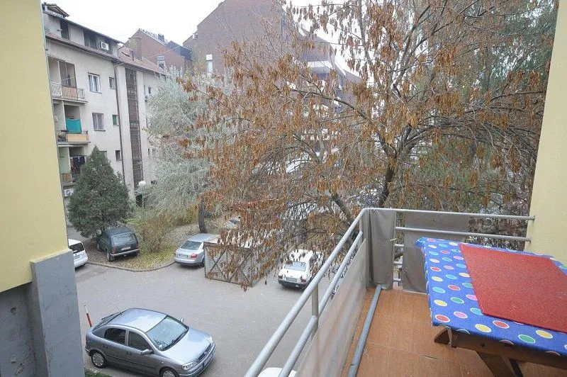 Pogled sa balkona na dvorište i okolne zgrade.