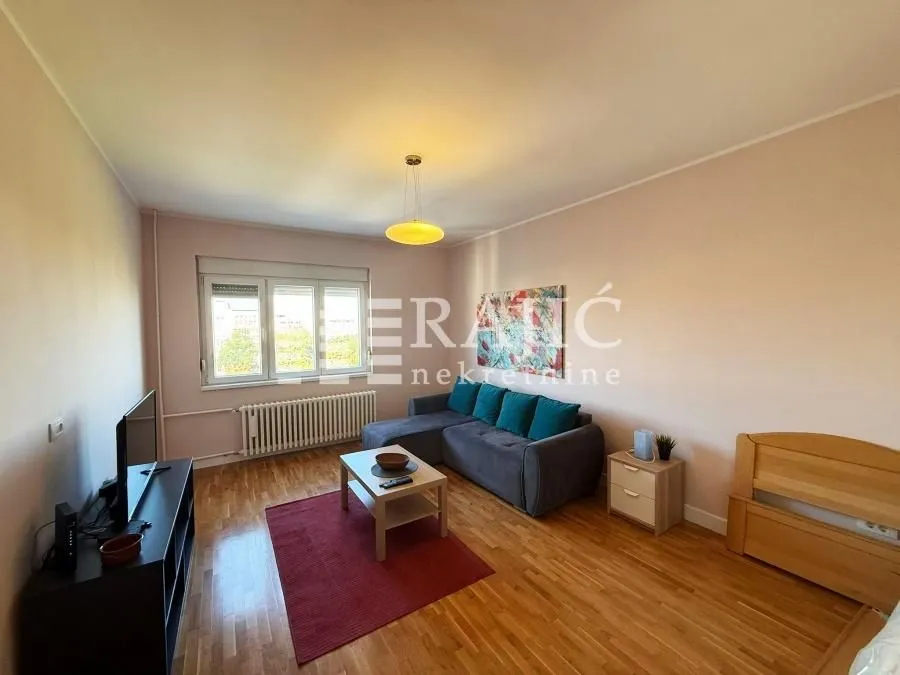 Living room with a sofa, coffee table, and TV cabinet.