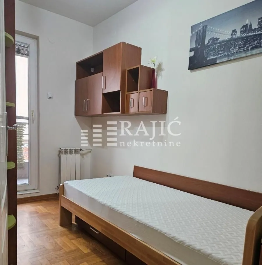 Furnished bedroom with a bed and wall cabinets.