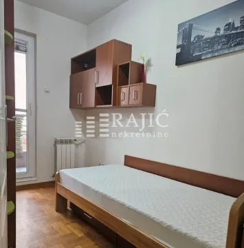 Furnished bedroom with a bed and wall cabinets. - image 7