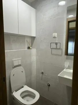 Small bathroom with white sanitary ware and grey wall tiles. - image 10