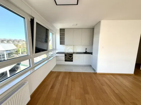 Small modern kitchen with white cabinets and large windows allowing plenty of natural light. - image 2