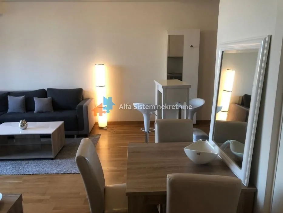 Living room with sofa, coffee table and dining area.