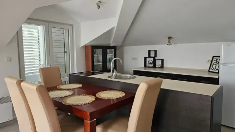 Kuhinja sa trpezarijskim stolom i stolicama u potkrovlju. - image 9