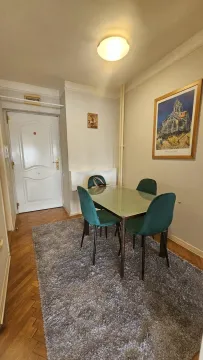 Trpezarijski sto sa zelenim stolicama u delu dnevnog boravka. - image 5