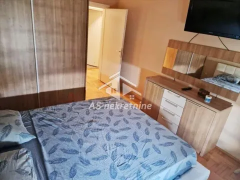 Furnished bedroom with a double bed, wardrobe, and a dresser with a mirror. - image 7