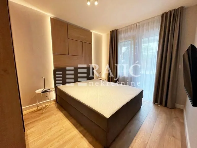 Modern bedroom with a double bed and wooden wall paneling.