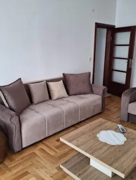 Living room with a sofa and a wooden coffee table. - image 6