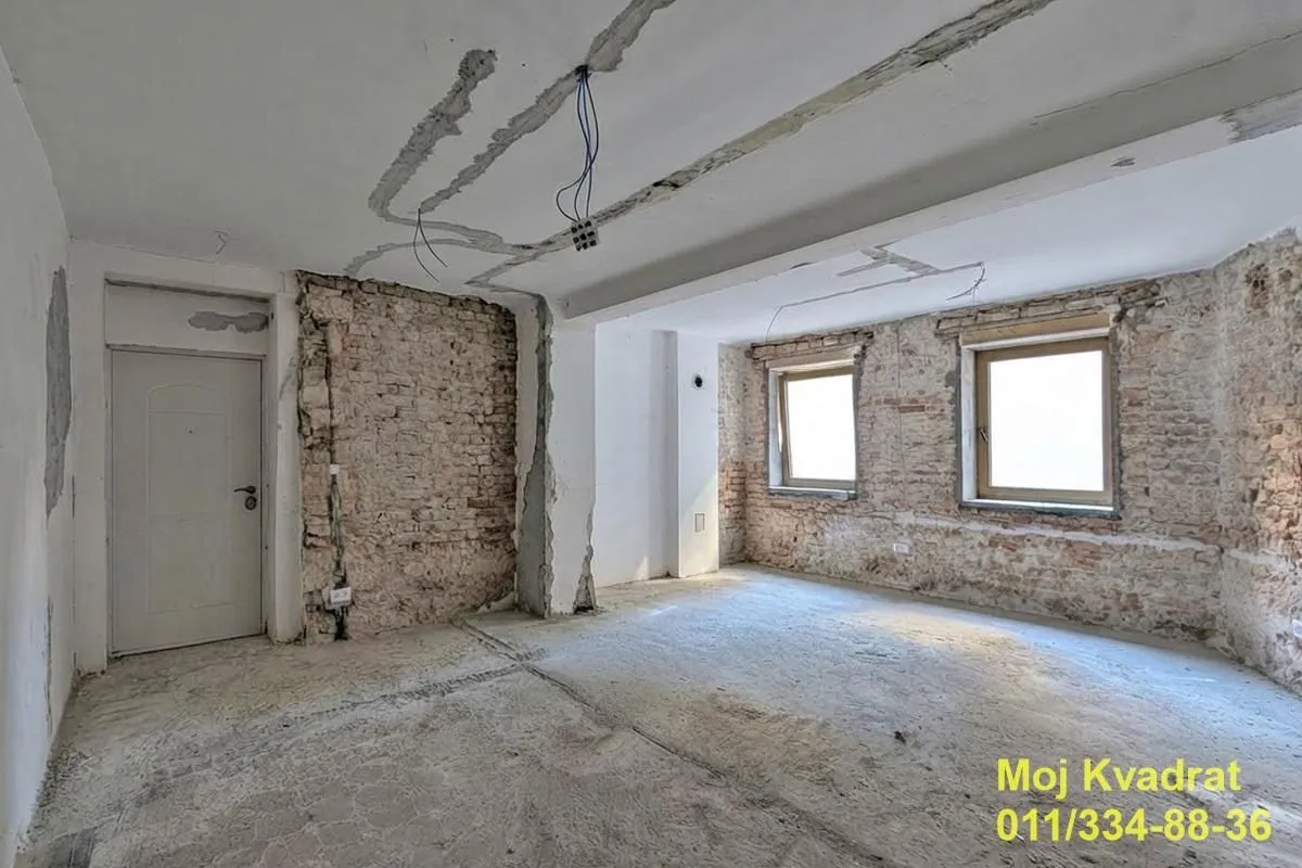 Prazna prostorija u toku renoviranja sa ogoljenim zidovima i plafonom.