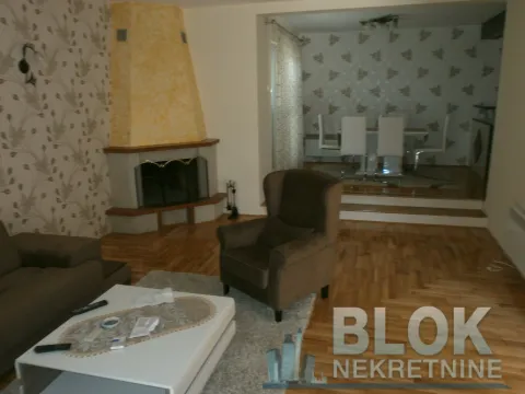Living room with a sofa set, armchair, fireplace and a view of the dining area. - image 7