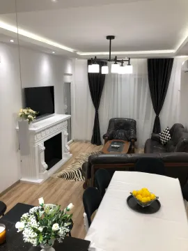 Spacious and bright living room with a fireplace and dining area. - image 18