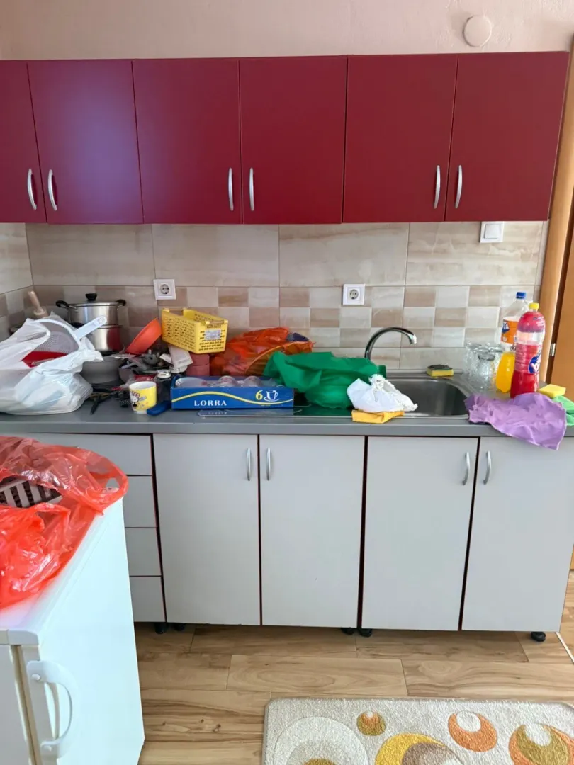 Messy kitchen with dishes and groceries on the countertop.