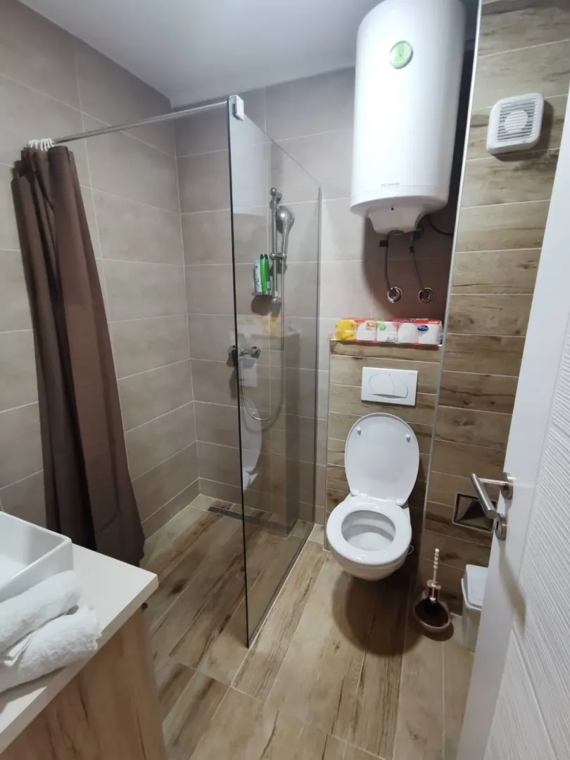 Moderno opremljeno kupatilo sa tuš kabinom, WC šoljom i umivaonikom.