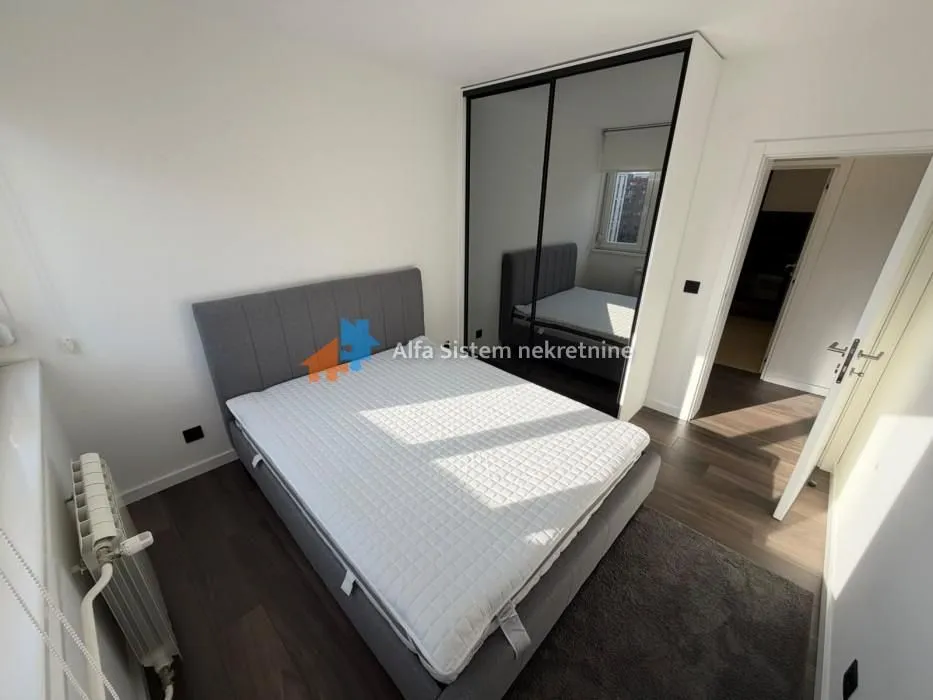 Bedroom with a double bed and a fitted wardrobe with a mirror.
