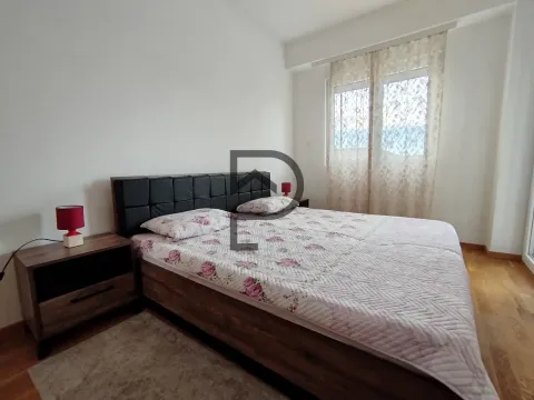 A bedroom featuring a double bed, bedside tables, and a window. - image 7