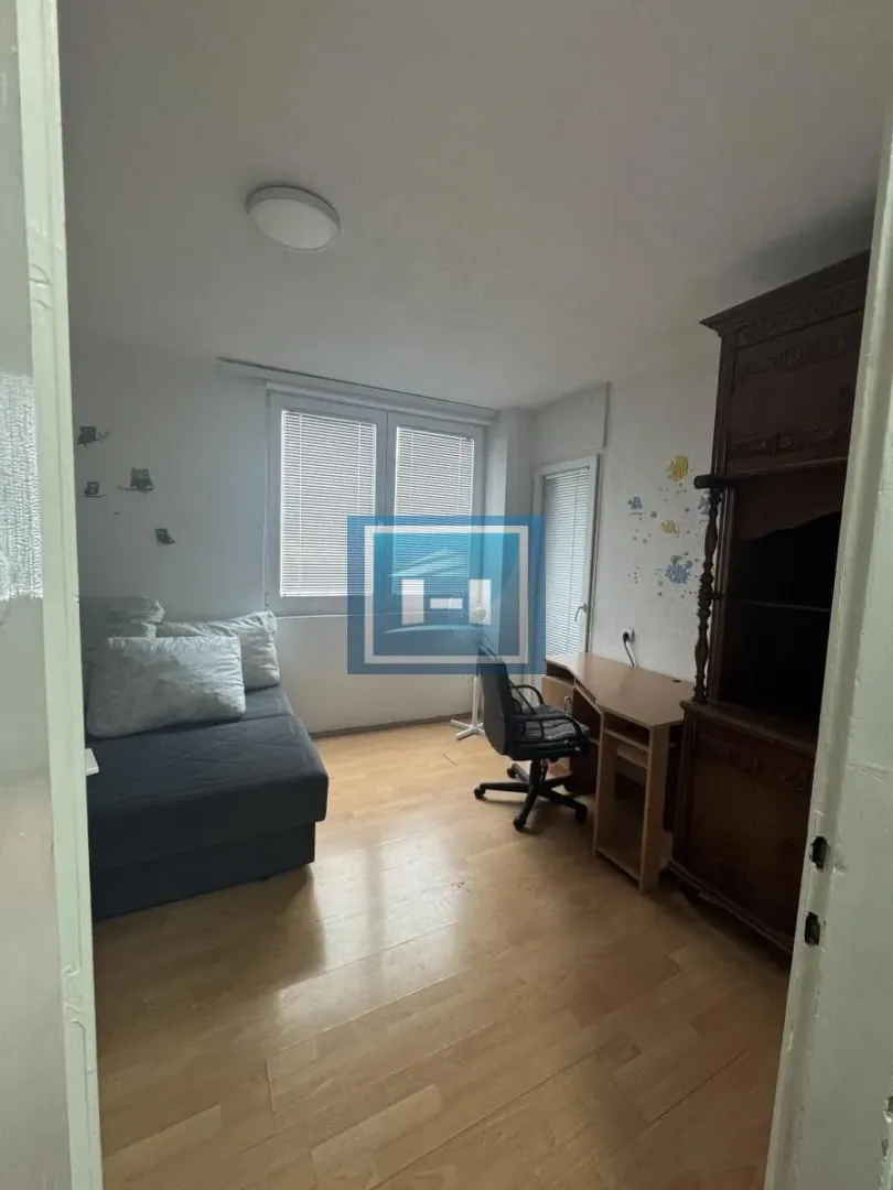 Small room with a bed, a desk, and a wooden wardrobe.