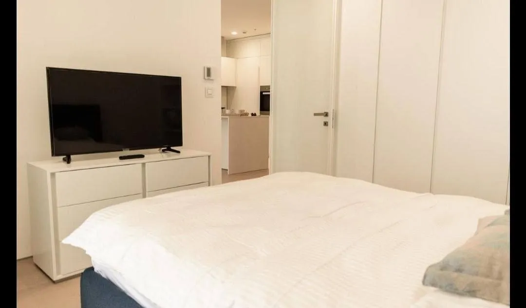 Furnished bedroom with a double bed, chest of drawers, and television.