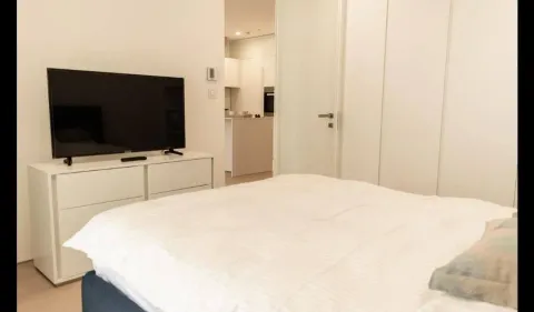 Furnished bedroom with a double bed, chest of drawers, and television. - image 3