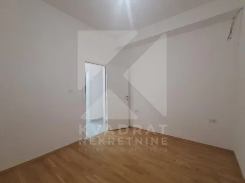 Prazna soba sa bijelim zidovima i drvenim podom. - image 9